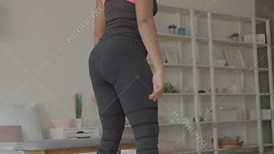 Midsection of fitness woman crouching at home