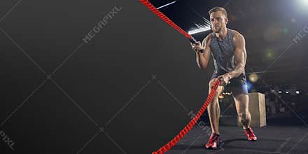 Young healthy man athlete doing exercise in the gym with ropes, flyer with copyspace