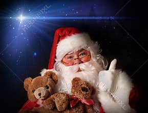 Santa smiling holding toy teddy bears