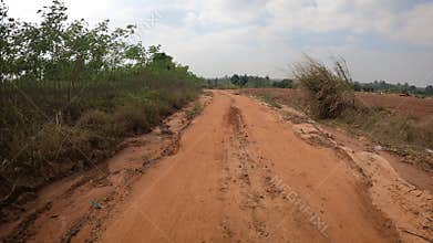Point of view running on a dirt road. Off-road truck car wheels move on the dirty road with dust, wet and dry mud.