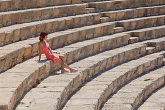 Girl is sitting on the steps of amphitheater