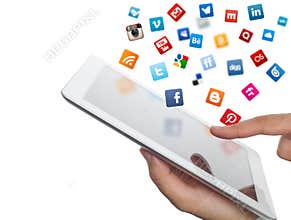 Social media icons fly off the ipad in hand