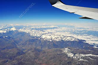 view from window plane of andes range mountains over chilean territory
