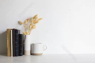 Minimal reading concept with books, coffee cups and flowers on wooden table.