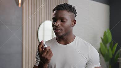 African American ethnic man applying fresh breath spray prevent stink morning hygiene of mouth preparing for date in
