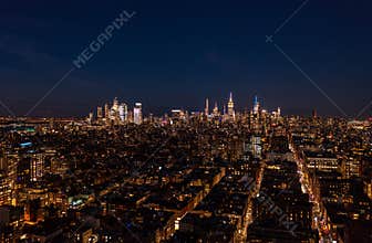 Night cityscape. Lighted windows in town development and illuminated skyscrapers in distance. Manhattan, New York City