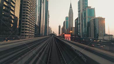 Dubai, UAE - 10th october, 2022: metro train on railway in Dubai with museum of future and sunset sky background with skyline