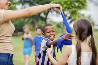 Children and teacher playing games in city park
