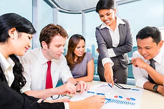 Asian business team discussing report