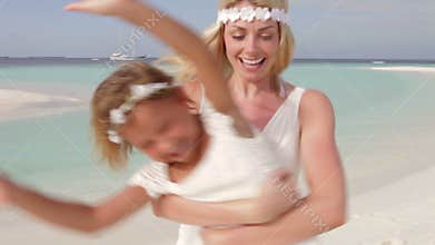 Bride Spinnning Bridesmaid Around At Beach Wedding