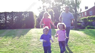 Family Playing Football In Garden Together
