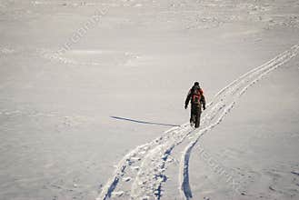 Man hiking in winter on a snow trail