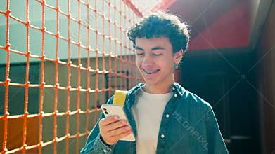 Smiling Caucasian man male happy teenager guy teen student teenage pupil modern technology using mobile phone smartphone