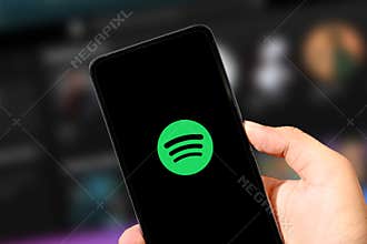 3.23.2025, United States. Person Using music streaming app spotify on the smartphone close up, illustrative editorial background