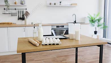 Modern kitchen setup with baking ingredients on wooden table