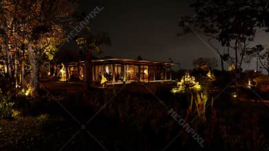Secluded cabin illuminated at night amidst forest trees, offering a tranquil and cozy