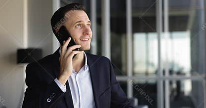 Serious Hispanic business executive man talking on mobile phone
