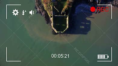 Aerial view of coastal ruins with video recording animation overlay