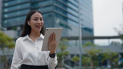 Cute Positive Productive Asian Woman Video Calling to her Clients on Digital Device.