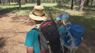 A young couple backpacking in the woods