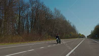 Steadicam shot of motorcycle convoy riding through a forest road