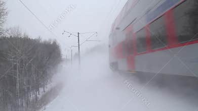 Modern train passes through the snowy railway