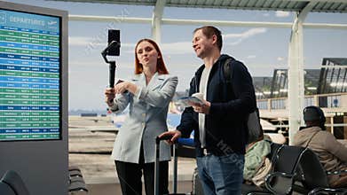 Man and woman influencers creating travel vlog in the airport