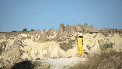 Woman sitting by red sandstone hoodoos in Cappadocia, Turkiye, turkey, travel, valley, fairy chimneys
