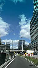 Modern office building and tram at urban street with blue sky and