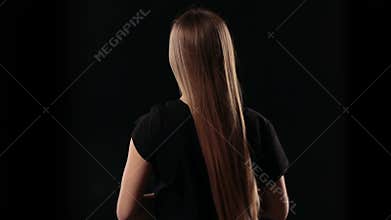Back view woman letting down blond straight hair