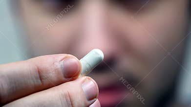 Man putting a pill in his mouth.