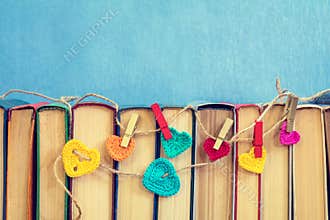 Many multicolor crochet hearts on books