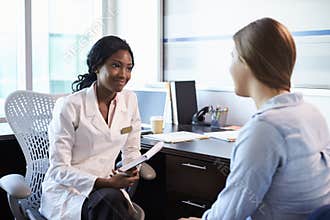Doctor In Consultation With Female Patient In Office