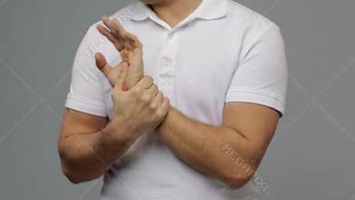 Unhappy man suffering from pain in hand