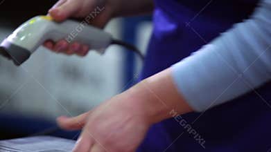 The woman scans the bar codes on the packages.