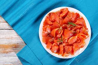 Slices of salted red fish on white plate