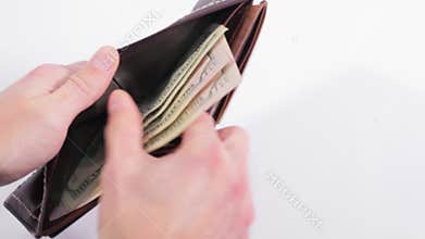 Brown purse on white background. Man recounts the cash from the purse and takes all. Close up