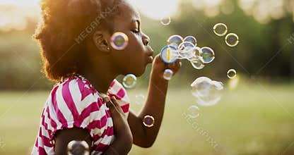 Children is playing bubbles in a park