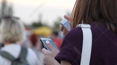 Woman with phone at outdoors, young girl communicat in social networks on party, female with mobile phone in hands