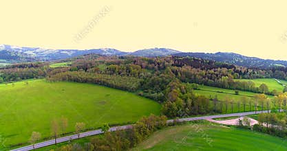 Stunning aerial shot over lush green fields and meadows in the countryside.