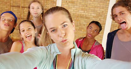 Female coach and high school kids taking a selfie