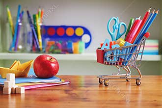 Back to School Shopping Cart with Supplies on Wooden Table.