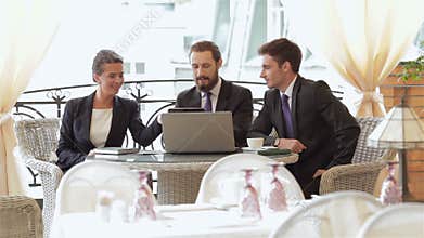 A woman and a two man on a business lunch