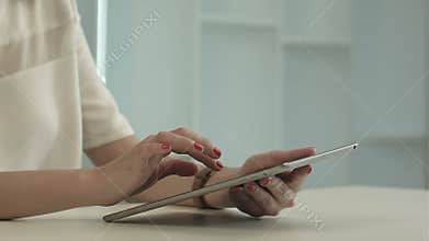Woman sitting in office table and touch tablet