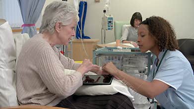 Nurse Checking On Senior Female Patient Having Chemotherapy
