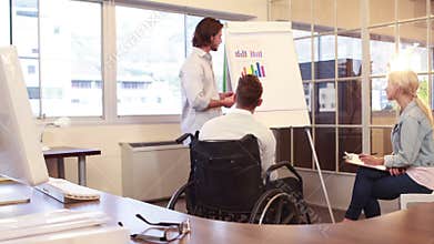 Casual businessman presenting graph to colleagues