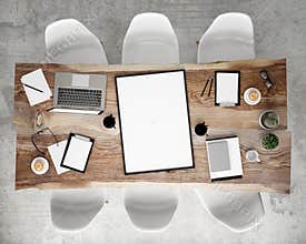 Mock up poster frame on meeting conference table with office accessories and laptop computers, hipster interior background,
