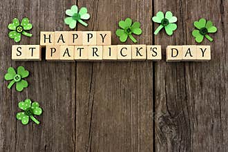 Happy St Patricks Day wooden blocks with shamrocks over wood