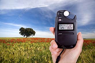 Photographer using lightmeter to measure light