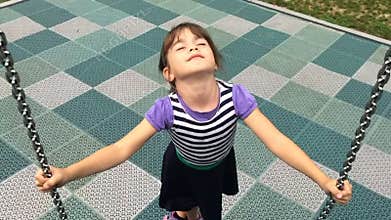 Slow motion of happy girl play on a net swing